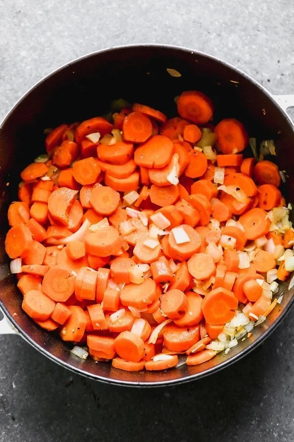 Cook carrots, onion, and garlic in butter.