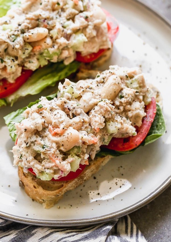 This is the Tuna White Bean Salad of my dreams. Easy to make, and packed with flaky tuna, creamy white beans, crunchy celery and red onion, and tossed a light dressing made with just enough low-fat mayo, lemon juice, &nbsp;and acidic white wine vinegar. Pair with hearty whole-grain bread and serve with crisp romaine lettuce and sliced tomatoes.&nbsp;