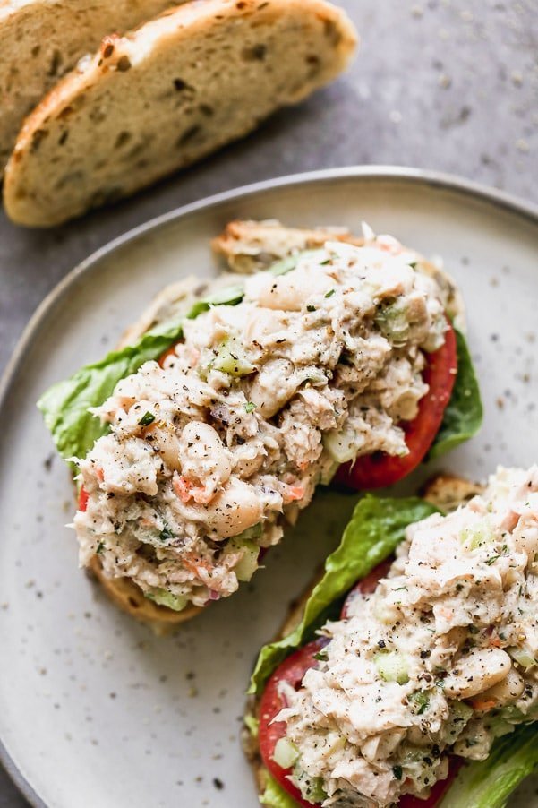 This is the Tuna White Bean Salad of my dreams. Easy to make, and packed with flaky tuna, creamy white beans, crunchy celery and red onion, and tossed a light dressing made with just enough low-fat mayo, lemon juice, &nbsp;and acidic white wine vinegar. Pair with hearty whole-grain bread and serve with crisp romaine lettuce and sliced tomatoes.&nbsp;