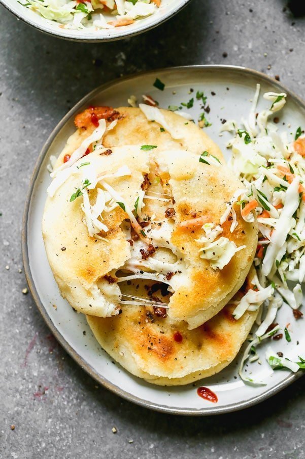 If you've never had Salvadoran Pupusas, you're in for a very delicious treat. Crispy corn flatbreads are stuffed with gooey oaxaca cheese and spicy chorizo, pan-fried until irresistibly crispy and then served with a simple slaw. Simple, but so delicious.&nbsp;