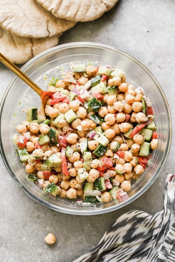 Cucumber and Chickpea Salad is refreshing, healthy, and packed with flavor and texture. It's simple. Hearty protein-packed chickpeas are tossed with crunchy cucumber, smoky roasted red peppers, and red onions. It's all tossed in a creamy red wine vinegar and tahini dressing with just a hint of smokiness from ground sumac. The perfect lunch or side for dinner.&nbsp;