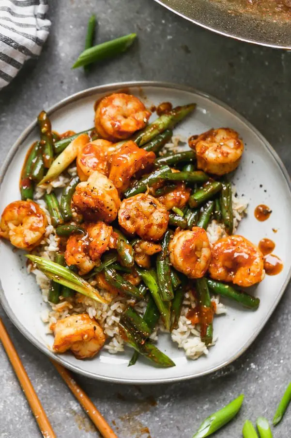 Hunan Shrimp is a hot and spicy shrimp dish packed with flavor from chili bean paste, garlic, soy sauce, and rice vinegar. The spicy plump shrimp are served with blistered green beans and green onions, and served over sticky brown rice. Ready in 20 minutes or less!&nbsp;