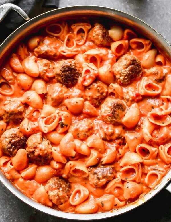 One Pot Creamy Tomato Pasta Sauce and Meatballs is spaghetti and meatballs meets vodka rigatoni, but it's all made neatly in one pot! Tender meatballs made with Italian sausage are seared until crusty and golden brown and then cooked with a creamy tomato sauce and adorable pipette shells. The perfect Sunday supper! 