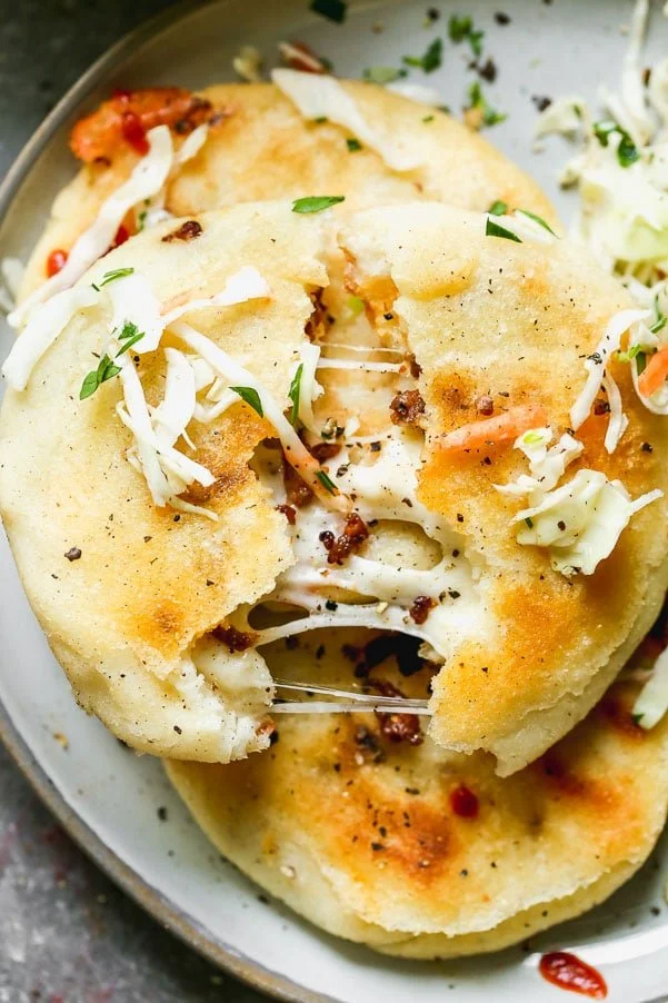 If you've never had Salvadoran Pupusas, you're in for a very delicious treat. Crispy corn flatbreads are stuffed with gooey oaxaca cheese and spicy chorizo, pan-fried until irresistibly crispy and then served with a simple slaw. Simple, but so delicious.&nbsp;