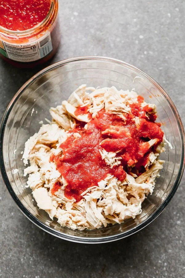 Mix shredded chicken, salsa, and salt together in a bowl. 