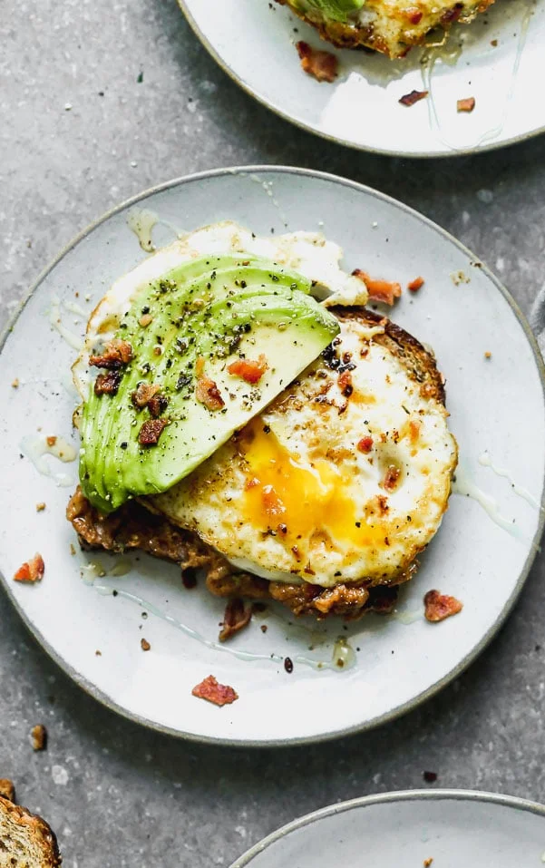 Our Favorite Avocado Toast with Egg has a couple of secret ingredients that make it different than most of the avocado toast recipes out there. Our version is slathered with nutty almond butter, top with a fried egg, lots of thinly sliced avocado, and then sprinkled with crumbled bacon and a little drizzle of honey and sea salt. It's the perfect medley of sweet, salty, and savory, and we can't get enough of it! 