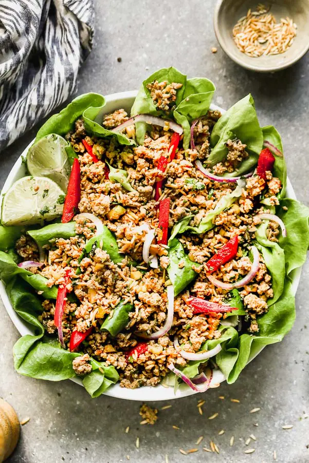 This Easy Chicken Larb Salad is the most FLAVORFUL meal. Ground turkey or chicken is tossed with zesty lime juice, fish sauce, and spicy chili sauce, served over a bed of mixed greens, red bell peppers, and red onion, and topped off with crispy toasted rice. Hearty, healthy, and so&nbsp;delicious.