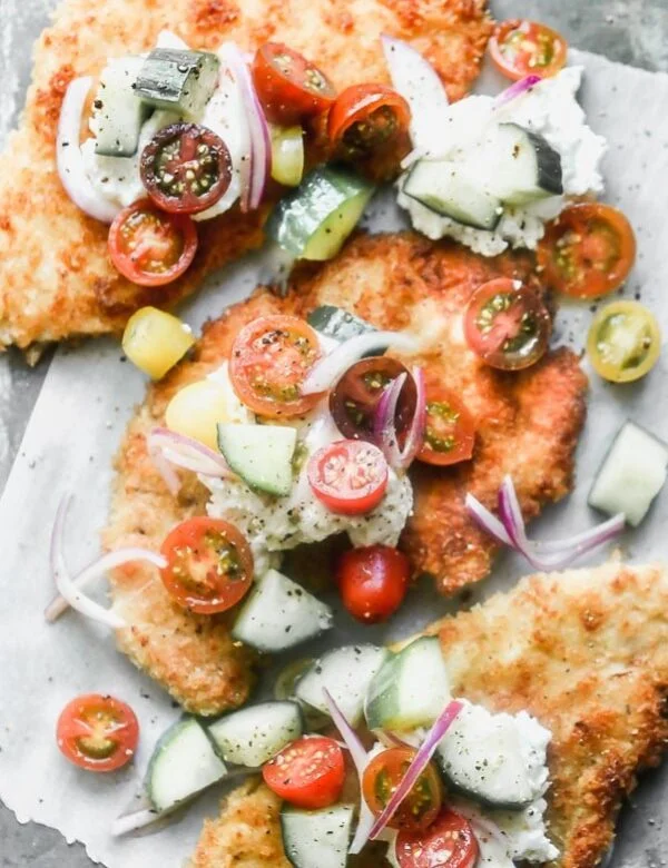 Crispy Chicken Cutlets are a cult-favorite in our family. We serve them all kinds of different ways, but our current favorite is serving them with a big dollop of creamy ricotta cheese and a zippy tomato and cucumber salad. 