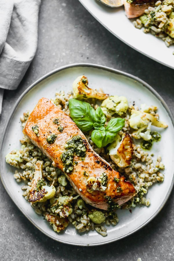 &nbsp;Salmon with Pesto and Roasted Cauliflower is an easy 5-ingredient full dinner! Yep, all you need is just five ingredients to create the crispiest, most flavorful salmon meal. We pan-sear salmon filets in a screaming hot cast iron skillet, and serve it over a bed of pesto farro studded with nutty roasted cauliflower. This is honestly the BEST five-ingredient meal you'll ever make!