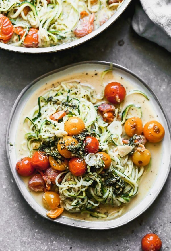 Our Zucchini Noodles with Burst Cherry Tomato Sauce and Pesto is a great way to get your pasta fix without all the calories. We toss zucchini noodles and a little bit of whole-wheat spaghetti with sweet blistered cherry tomatoes, creamy ricotta, and a touch of parmesan cheese. We finish it off with a drizzle of pesto and serve!&nbsp;