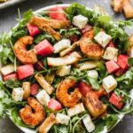 Blackened Shrimp and Halloumi Salad - have you seen a prettier combination? We take take peppery arugula leaves and toss them in a simple vinaigrette and then layer them with sweet watermelon, salty halloumi cheese, toasted pita croutons, and spicy blackened shrimp. It's hearty, healthy, and SO delicious. 