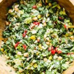 This easy throw-it-together chopped chickpea and tahini salad is hearty and healthy thanks to the addition of chopped green beans, bell peppers, spinach, roasted red peppers, and chickpeas. We add in slivered almonds and pecans for a little bit of crunch and toss everything in an easy lemon and tahini dressing.