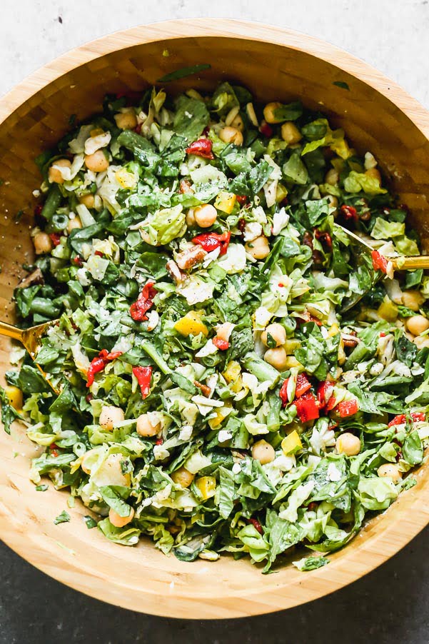 This easy throw-it-together chopped chickpea and tahini salad is hearty and healthy thanks to the addition of chopped green beans, bell peppers, spinach, roasted red peppers, and chickpeas. We add in slivered almonds and pecans for a little bit of crunch and toss everything in an easy lemon and tahini dressing.