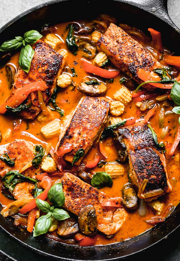 Red Curry Salmon&nbsp;with Veggie is not only a show-stopper to look at, but it's seriously delicious - and easy to make! Yep, this one-pan, 30-minute meal is E-A-S-Y to throw together on a whim, and we can't get enough it. We take center-cut portions of Atlantic salmon, sear them until irresistibly crispy on the outside and buttery on the inside and then simmer them in a sweet and spicy coconut curry sauce. We nestle in tons of veggies - portabella mushrooms, baby corn, spinach, red peppers, and onions - and then sprinkle it with a little bit of fresh basil. SO good.&nbsp;