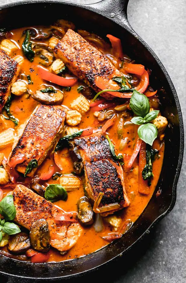 Red Curry Salmon and Veggies. Seared salmon in a curry and coconut broth with baby corn, red peppers, and mushrooms. 