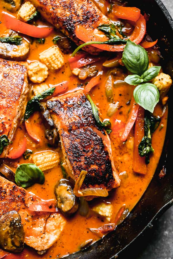 Red Curry Salmon&nbsp;with Veggie is not only a show-stopper to look at, but it's seriously delicious - and easy to make! Yep, this one-pan, 30-minute meal is E-A-S-Y to throw together on a whim, and we can't get enough it. We take center-cut portions of Atlantic salmon, sear them until irresistibly crispy on the outside and buttery on the inside and then simmer them in a sweet and spicy coconut curry sauce. We nestle in tons of veggies - portabella mushrooms, baby corn, spinach, red peppers, and onions - and then sprinkle it with a little bit of fresh basil. SO good.&nbsp;