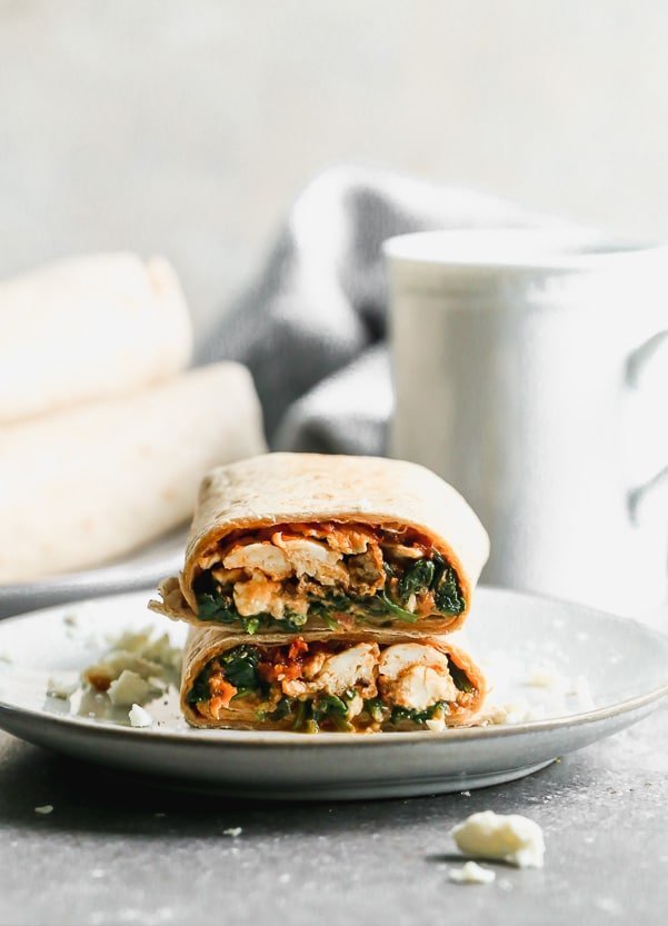 Our Copycat Starbucks Spinach Feta Wrap is the perfect on-the-go breakfast for busy mornings. We stuff a whole-wheat tortilla with egg whites, wilted baby spinach, salty feta, and a sun-dried tomato pesto. The wraps are crisped up in a hot skillet until golden brown and ready to eat.&nbsp;