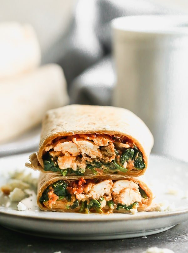 Our Copycat Starbucks Spinach Feta Wrap is the perfect on-the-go breakfast for busy mornings. We stuff a whole-wheat tortilla with egg whites, wilted baby spinach, salty feta, and a sun-dried tomato pesto. The wraps are crisped up in a hot skillet until golden brown and ready to eat.&nbsp;