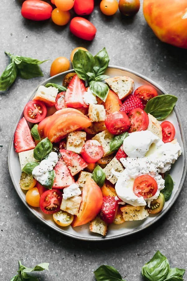 If there were ever a salad that represented summer it would be this Burrata Panzanella. We coat toasted cheesy bread croutons, juicy heirloom tomatoes, and strawberries in an easy honey lemon vinaigrette and then nestle creamy truffle burrata on top along with as much fresh basil as your yeart desires. Garnish with freshly cracked black pepper and flaky pieces of maldon sea salt.