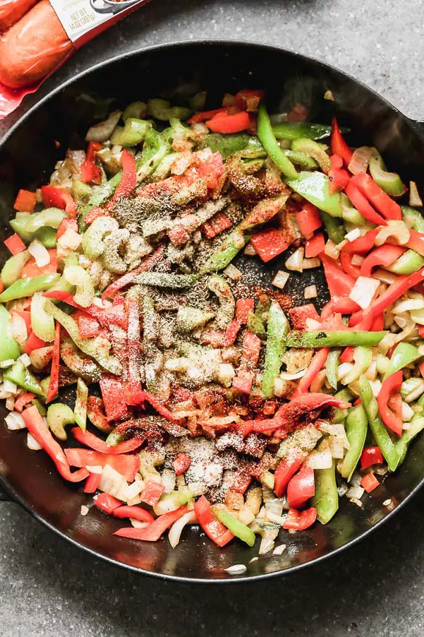 Sauté green peppers, red peppers, onions, and spices.