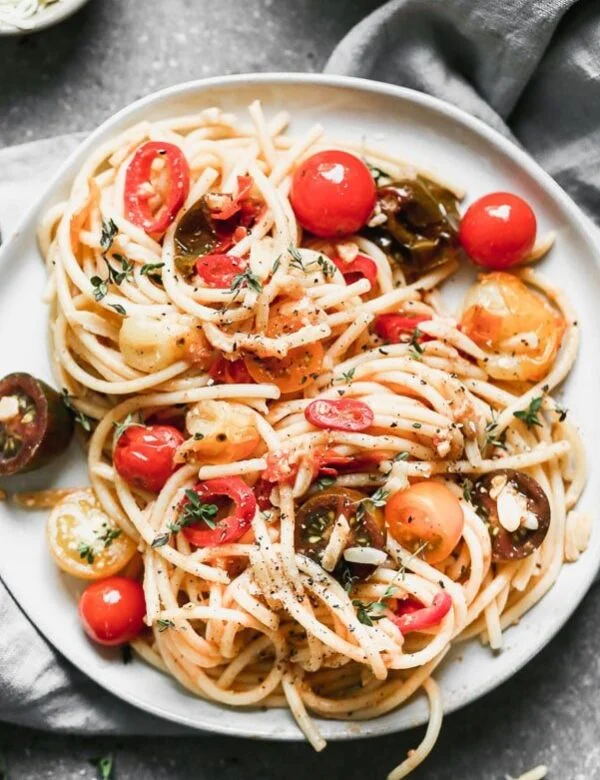 Spicy Bucatini Recipe: We cook cherry tomatoes and spicy fresno chilies in butty brown butter, and then toss it with chewy bucatini noodles, toasted almonds, fresh thyme, and plenty of garlic. A little bit of salty, starchy pasta water and parmesan cheese finish off this irresistibly spicy, nutty summer to fall pasta. 