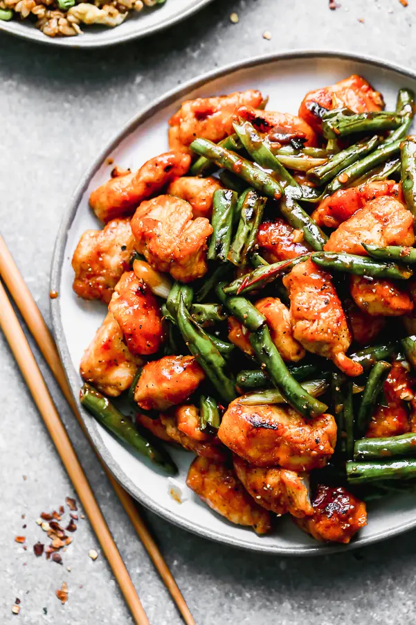 Hunan Chicken is our answer when we're craving super spicy Asian food. We take tender chicken tenders and stir-fry them until crisp, along with green beans and then coat it all in a super easy, fiery, and tangy chili bean sauce. 25 minutes of prep and cook time, virtually fool proof. 