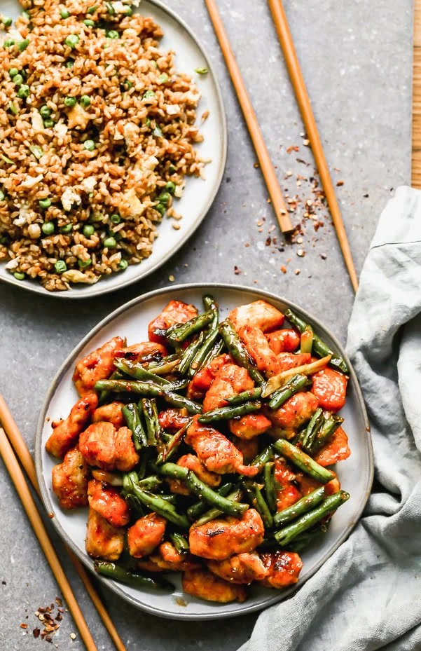 Hunan Chicken is our answer when we're craving super spicy Asian food. We take tender chicken tenders and stir-fry them until crisp, along with green beans and then coat it all in a super easy, fiery, and tangy chili bean sauce. 25 minutes of prep and cook time, virtually fool proof. 