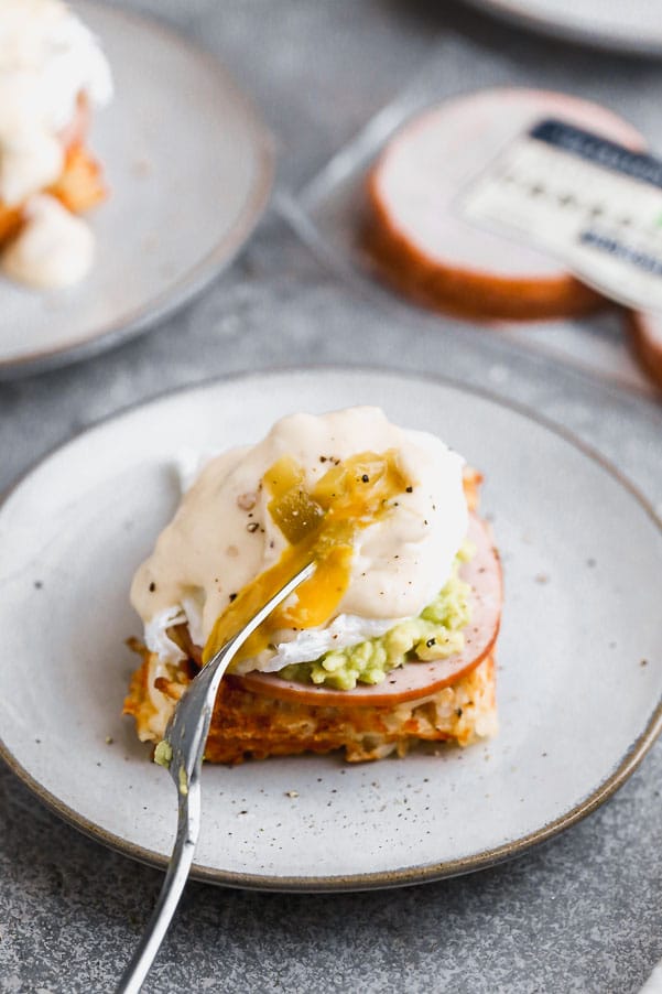 Our Green Chile Avocado Eggs Benedict swaps out an English muffin for a cheesy, crispy hash brown waffle base. We top it with citrusy smashed avocado, hickory-smoked Canadian Bacon and a cheesy green chile-infused mornay sauce. Brunch heaven!