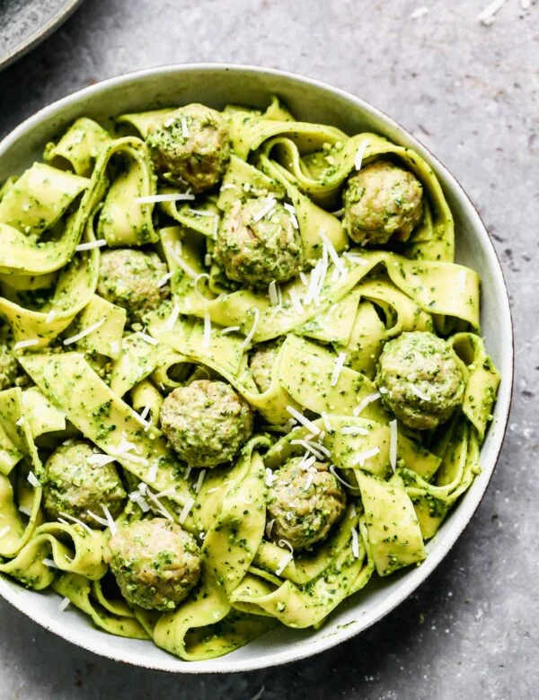 Twirly noodles tossed in a five-minute kale pesto, tender chicken meatballs, and plenty of nutty parmesan are the makings of our new favorite throw-it-together weeknight meal – Kale Pesto Pasta. Just because it's winter, doesn't mean we have to leave homemade pesto behind. Swapping out hearty wintery kale for a portion of the pesto brings a little seasonal aspect to our pesto and using crunchy almonds instead of pine nuts make this easy meal pocket-friendly as well. 