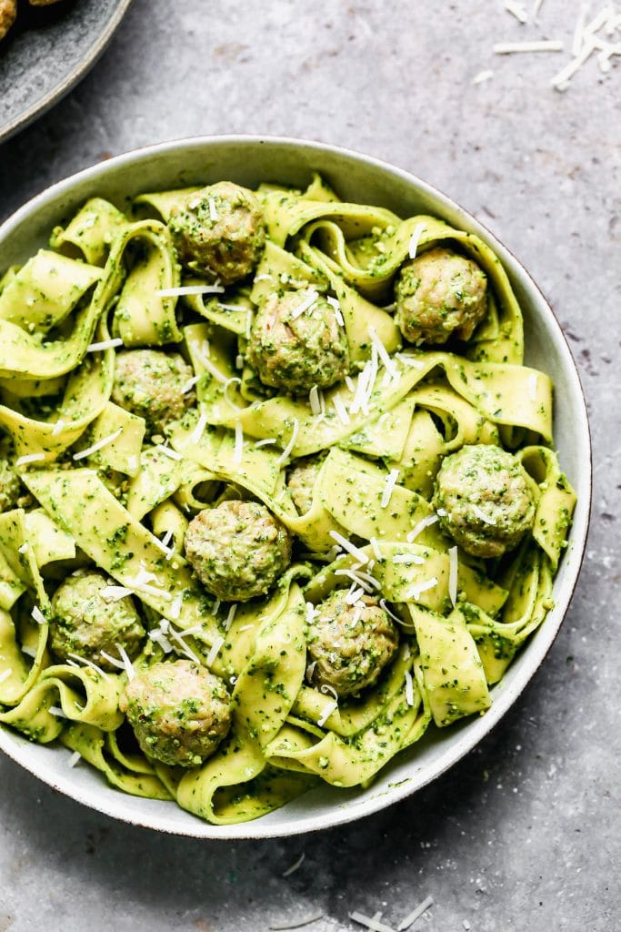 Twirly noodles tossed in a five-minute kale pesto, tender chicken meatballs, and plenty of nutty parmesan are the makings of our new favorite throw-it-together weeknight meal – Kale Pesto Pasta. Just because it's winter, doesn't mean we have to leave homemade pesto behind. Swapping out hearty wintery kale for a portion of the pesto brings a little seasonal aspect to our pesto and using crunchy almonds instead of pine nuts make this easy meal pocket-friendly as well. 