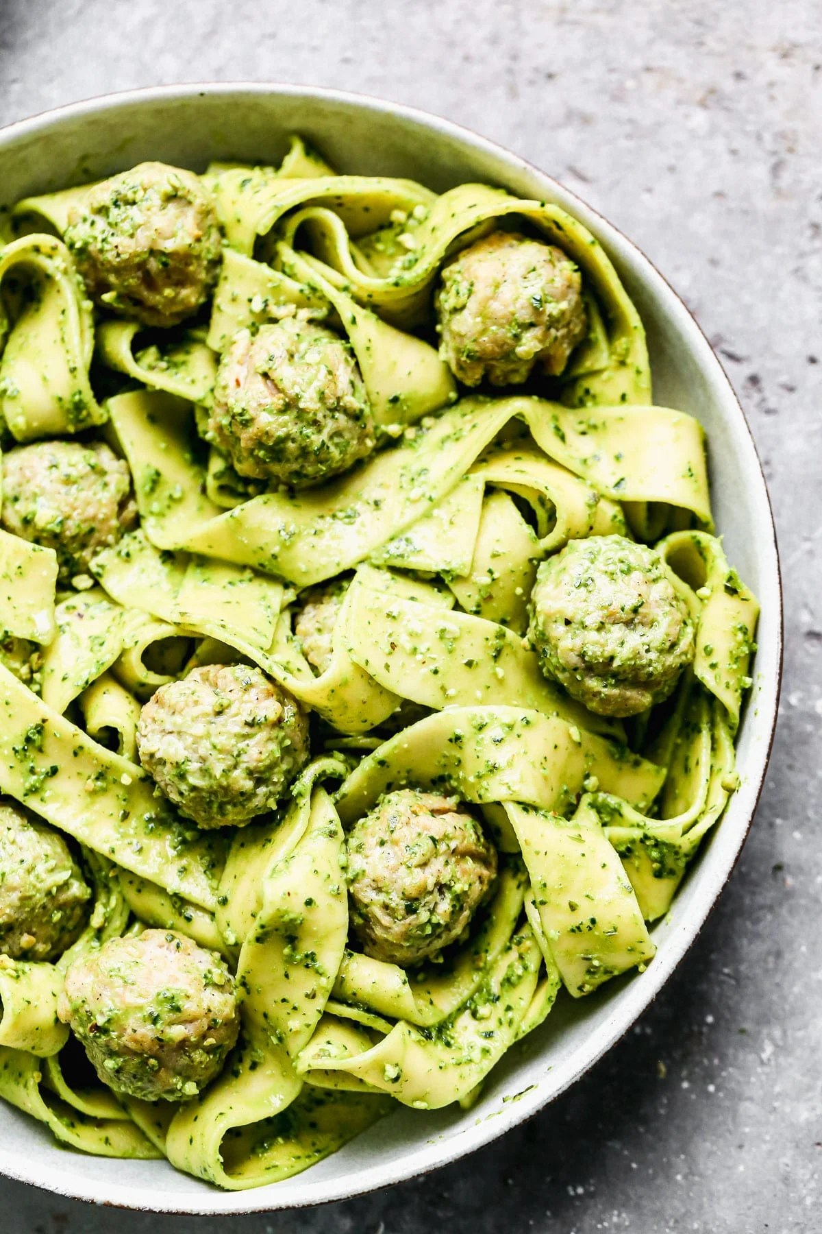 Twirly noodles tossed in a five-minute kale pesto, tender chicken meatballs, and plenty of nutty parmesan are the makings of our new favorite throw-it-together weeknight meal – Kale Pesto Pasta. Just because it's winter, doesn't mean we have to leave homemade pesto behind. Swapping out hearty wintery kale for a portion of the pesto brings a little seasonal aspect to our pesto and using crunchy almonds instead of pine nuts make this easy meal pocket-friendly as well. 