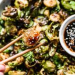 Crispy on the edges, soft on the inside, and dusted with the perfect amount of seasoning, our Air Fryer Brussels Sprouts are the perfect quick and easy veggies to make any night of the week. Once the Brussels sprouts are done in the air fryer we toss them in a sticky homemade honey soy glaze, sprinkle with sesame seeds and then serve with extra sauce for dipping. (You'll want to dip.)