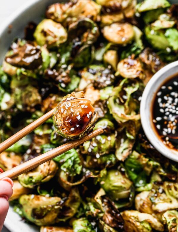Crispy on the edges, soft on the inside, and dusted with the perfect amount of seasoning, our Air Fryer Brussels Sprouts are the perfect quick and easy veggies to make any night of the week. Once the Brussels sprouts are done in the air fryer we toss them in a sticky homemade honey soy glaze, sprinkle with sesame seeds and then serve with extra sauce for dipping. (You'll want to dip.)