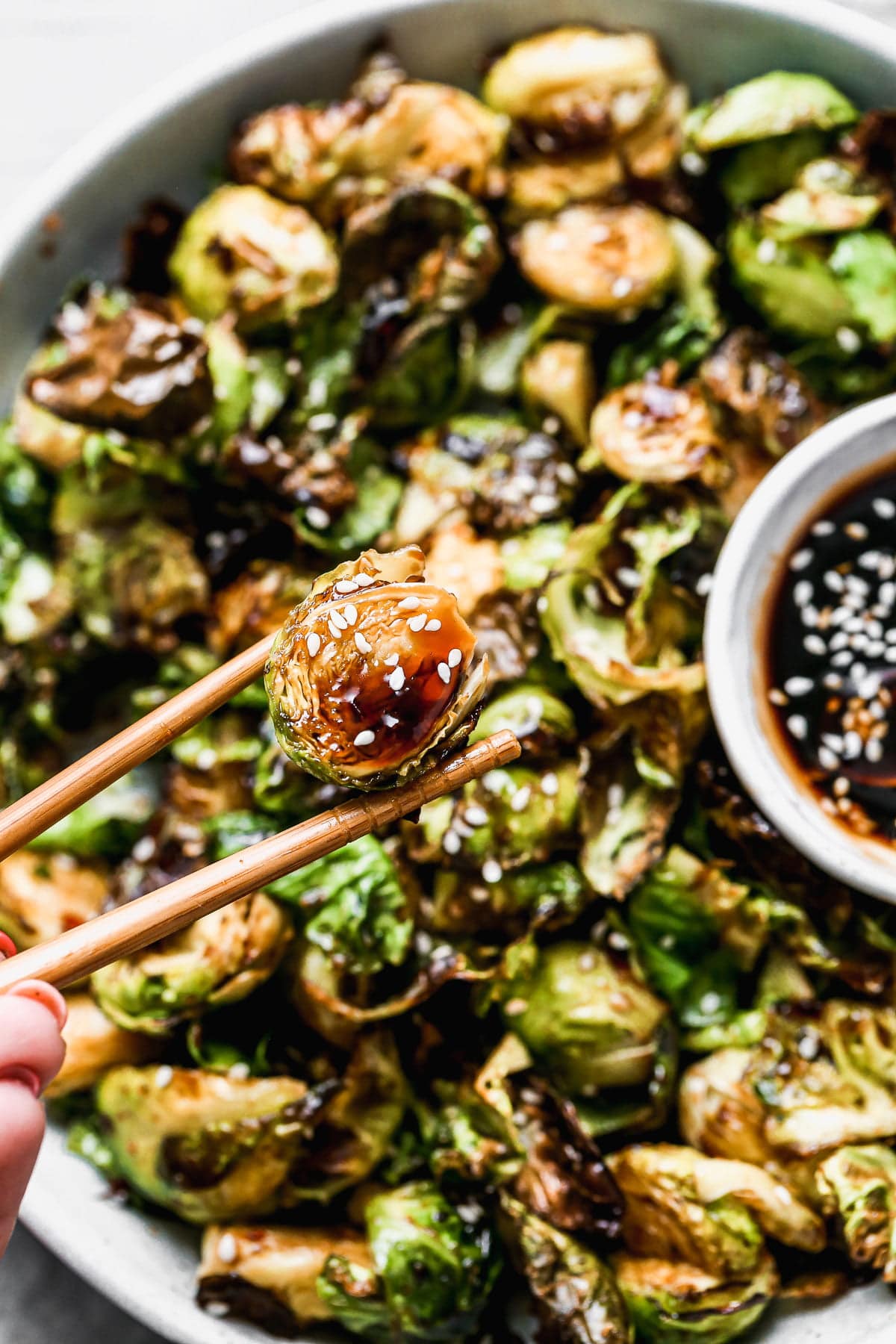 Crispy on the edges, soft on the inside, and dusted with the perfect amount of seasoning, our Air Fryer Brussels Sprouts are the perfect quick and easy veggies to make any night of the week. Once the Brussels sprouts are done in the air fryer we toss them in a sticky homemade honey soy glaze, sprinkle with sesame seeds and then serve with extra sauce for dipping. (You'll want to dip.)