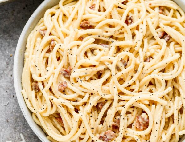 Silky-smooth noodles twirled in a rich, creamy (but cream-less) sauce, nutty pecorino cheese, and bits of salty bacon, our Bucatini Carbonara is the ultimate in Italian comfort food and arguably, the simplest.  Our version amps up the amount of both cheese and bacon, adds in a little bit of garlic, and swaps out classic spaghetti for thick bucatini noodles.