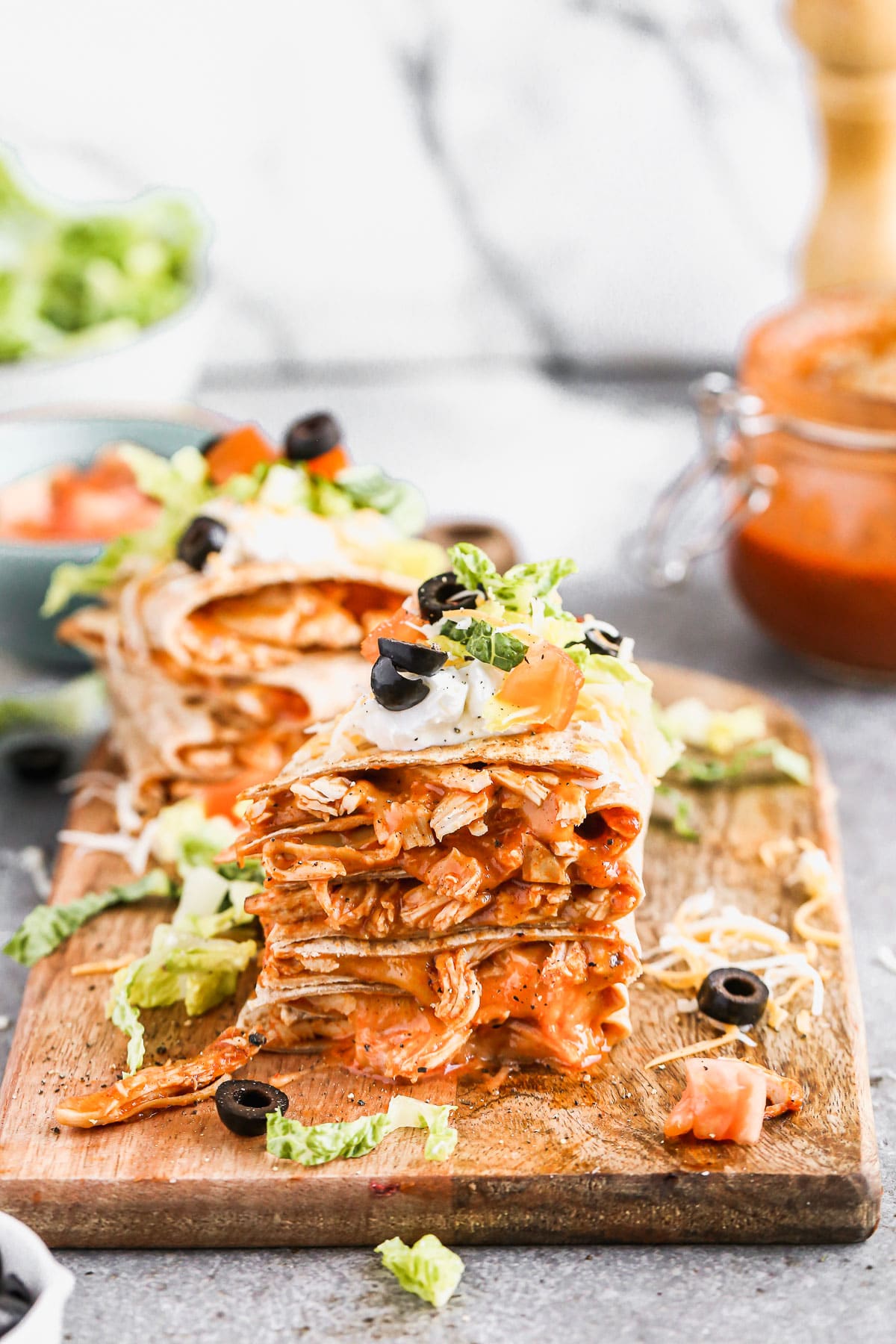 Chicken&nbsp;enchilada on the inside, taco on the outside is what makes our&nbsp;Chicken Enchilada Taco Quesadillas&nbsp;the&nbsp;perfect&nbsp;handheld hybrid of three classic tex-mex dishes. Each whole-wheat tortilla is filled with saucy shredded chicken (made with our epic homemade enchilada sauce) and cheese, pan-fried and then smothered with all your favorite taco fixings!&nbsp;