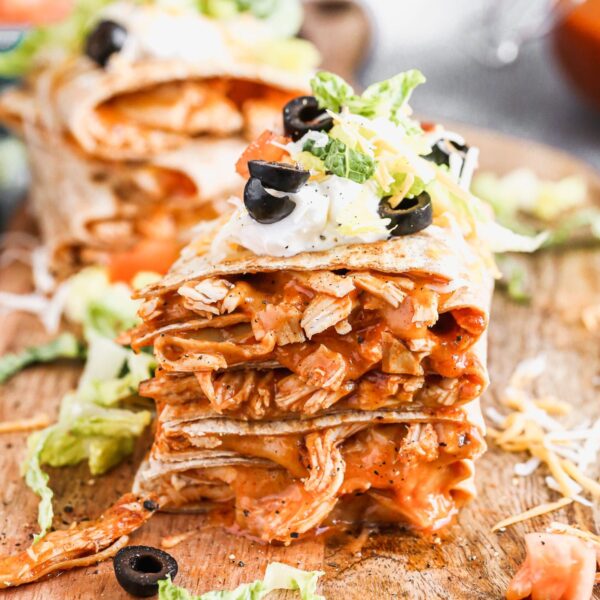 Chicken enchilada on the inside, taco on the outside is what makes our Chicken Enchilada Taco Quesadillas the perfect handheld hybrid of three classic tex-mex dishes. Each whole-wheat tortilla is filled with saucy shredded chicken (made with our epic homemade enchilada sauce) and cheese, pan-fried and then smothered with all your favorite taco fixings! 