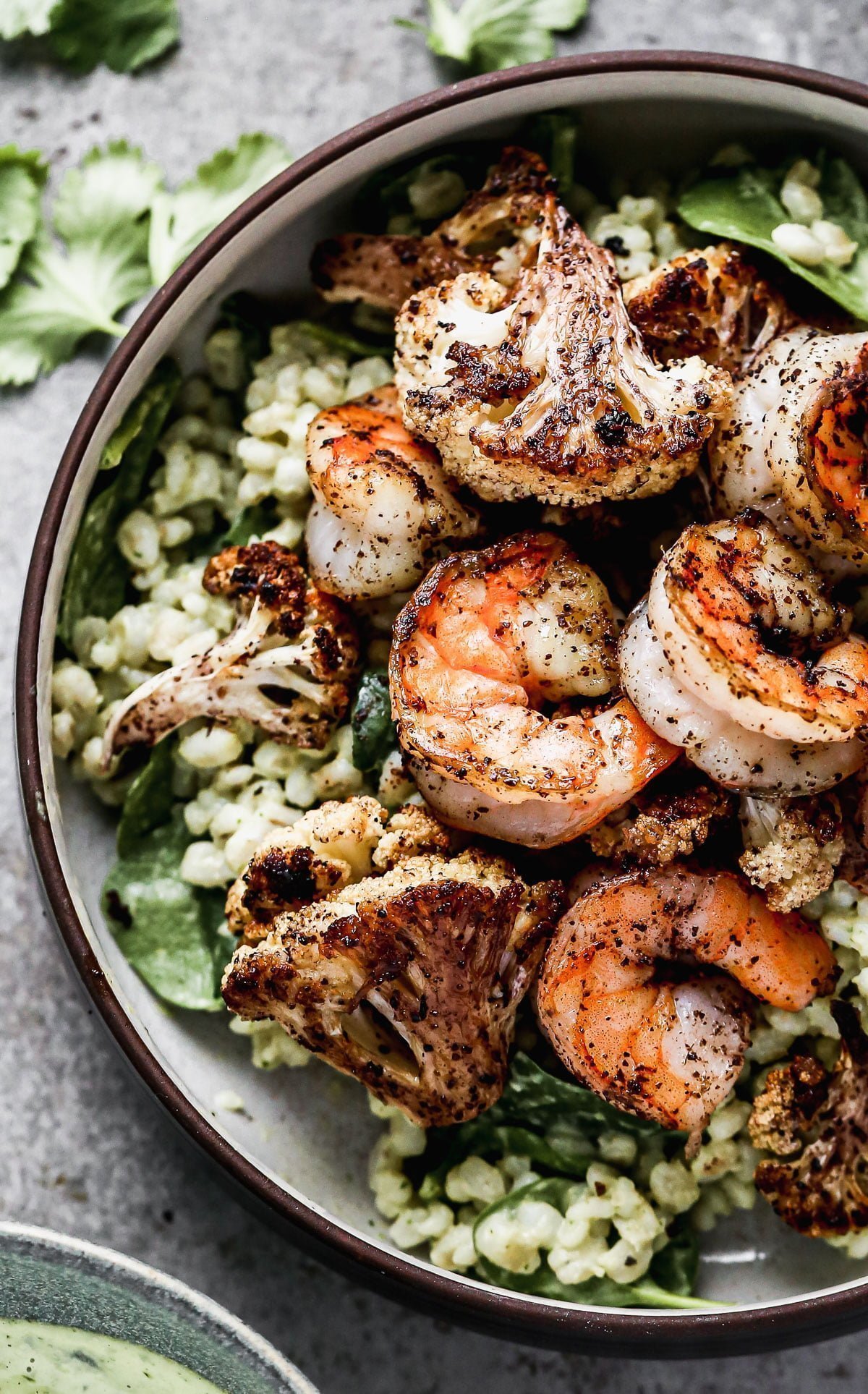 Nutty barley tossed in a zippy green tahini sauce, lemony sumac-roasted cauliflower and shrimp, and pops of crunchy pine nuts are the makings of our Green Tahini Shrimp Bowls - our new favorite way to do healthy. Make everything and serve the day of or pack it up and keep in the fridge to serve thought the week.&nbsp;