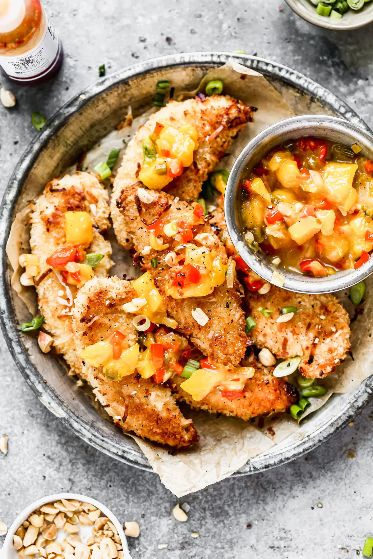 Let's all satisfy the kid in us with these ultra crispy, completely irresistible Baked Coconut Chicken Tenders. We coat tender chicken in a light coconut and panko breading, bake them on a screaming hot baking sheet and then serve them with a quick warm mango salsa and a hot honey drizzle.&nbsp;