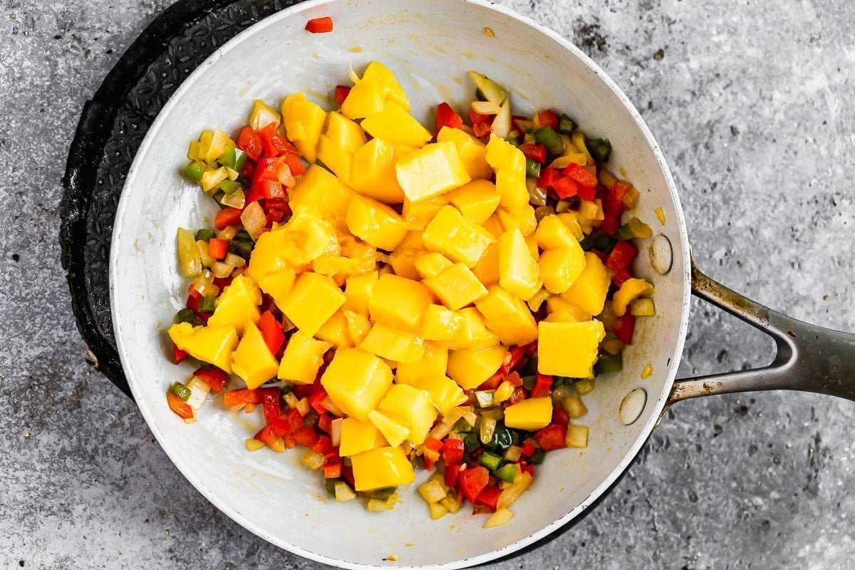 Warm mango salsa cooked in a skillet. 