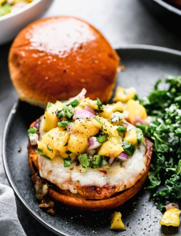 Packed with a homemade cajun seasoning, sweet onion, and seared until blackened and crisp on the edges and irresistibly juicy and moist on the inside, our Cajun Chicken Burgers are our new favorite way to do a burger. We smother the spicy patties with melty pepper jack cheese, cover them with an easy mango salsa and top with a sweet Hawaiian roll. 