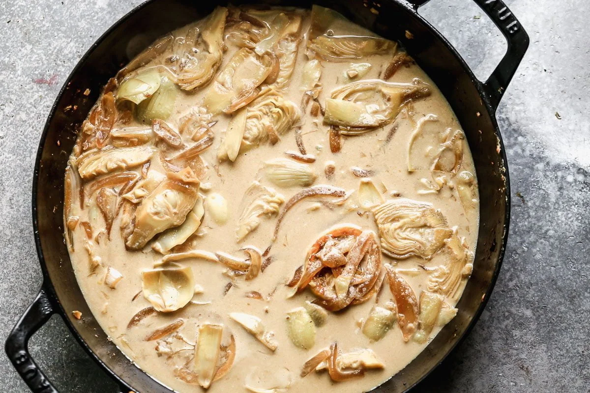 Simmer artichokes and caramelized onions with sauce