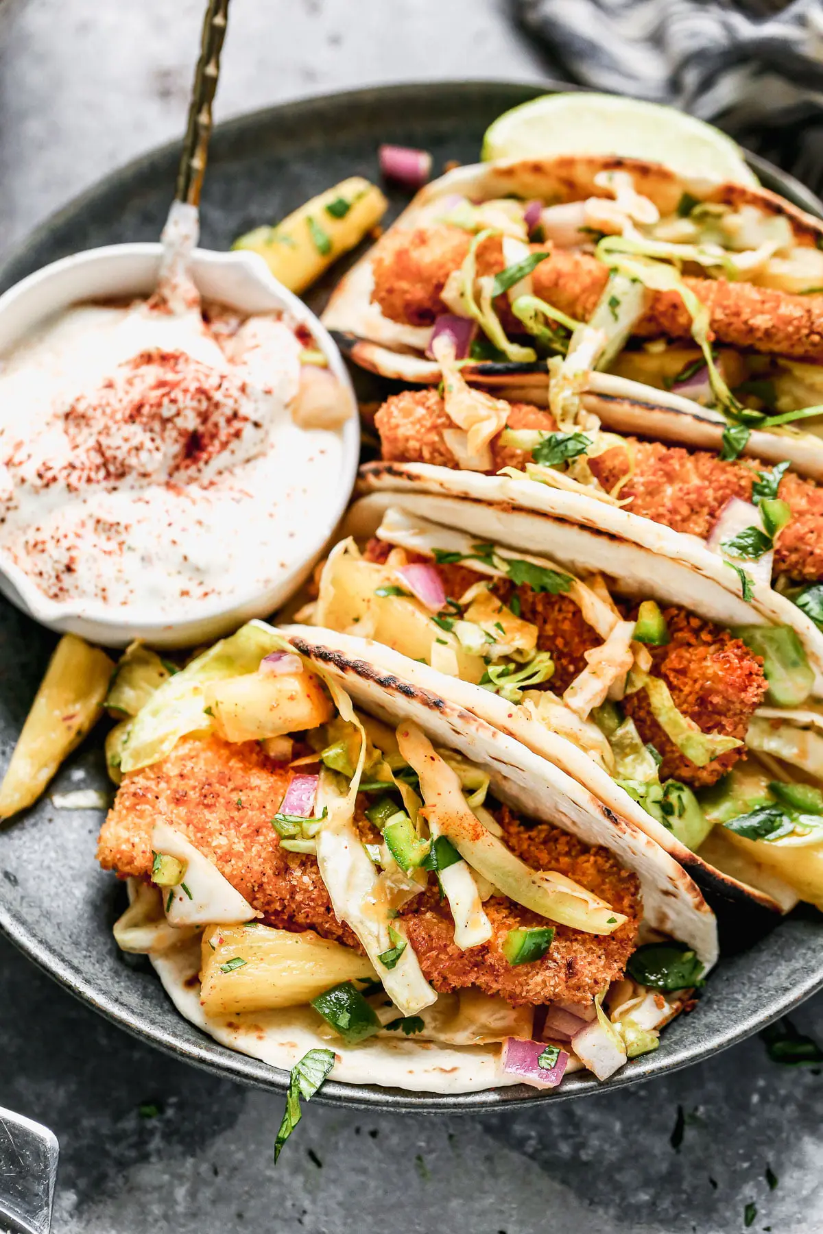 Never have a soggy fish taco again! Our Air Fryer Fish Tacos produce the CRISPIEST breaded fish without all the fat and calories and WITH all the flavor. We nestle the crunchy barramundi in charred street taco tortillas, top with a quick pineapple slaw, and a fresh squeeze of lime juice. 