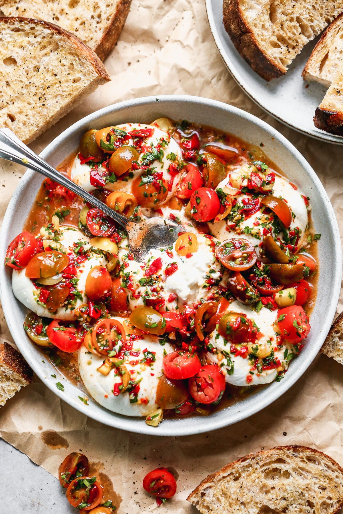 This Calabrian Chili and Burrata Appetizer is going to be the star of all your summer gatherings. This is basically a classic bruschetta but so so much better. We take juicy heirloom cherry tomatoes and toss them with fiery calabrian chilis, zippy red wine vinegar, parsley, garlic, and a few briny capers. We spoon it over the most adorable mini creamy burrata balls and serve with crusty bread to soak up every juicy bite.&nbsp;