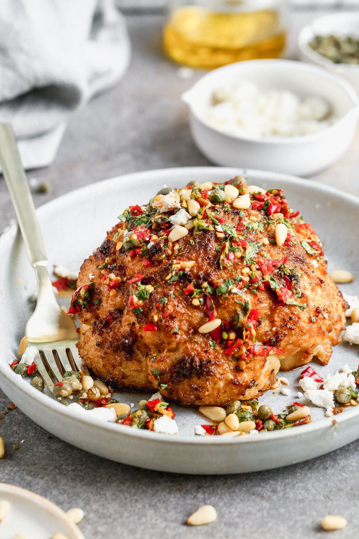 Visually beautiful and even tastier to eat, our Whole Roasted Cauliflower is THE vegetable recipe worthy of a permanent place in your dinner rotation. We steam a whole head of cauliflower, rub with with spices and then roast until it's tender on the inside and ultra crispy on top. &nbsp;We cover it in an easy Calabrian Chili Chimichurri, sprinkle with toasted pine nuts, and finish it off with salty feta cheese. Eat a whole one for a meal or share with others as a side dish.