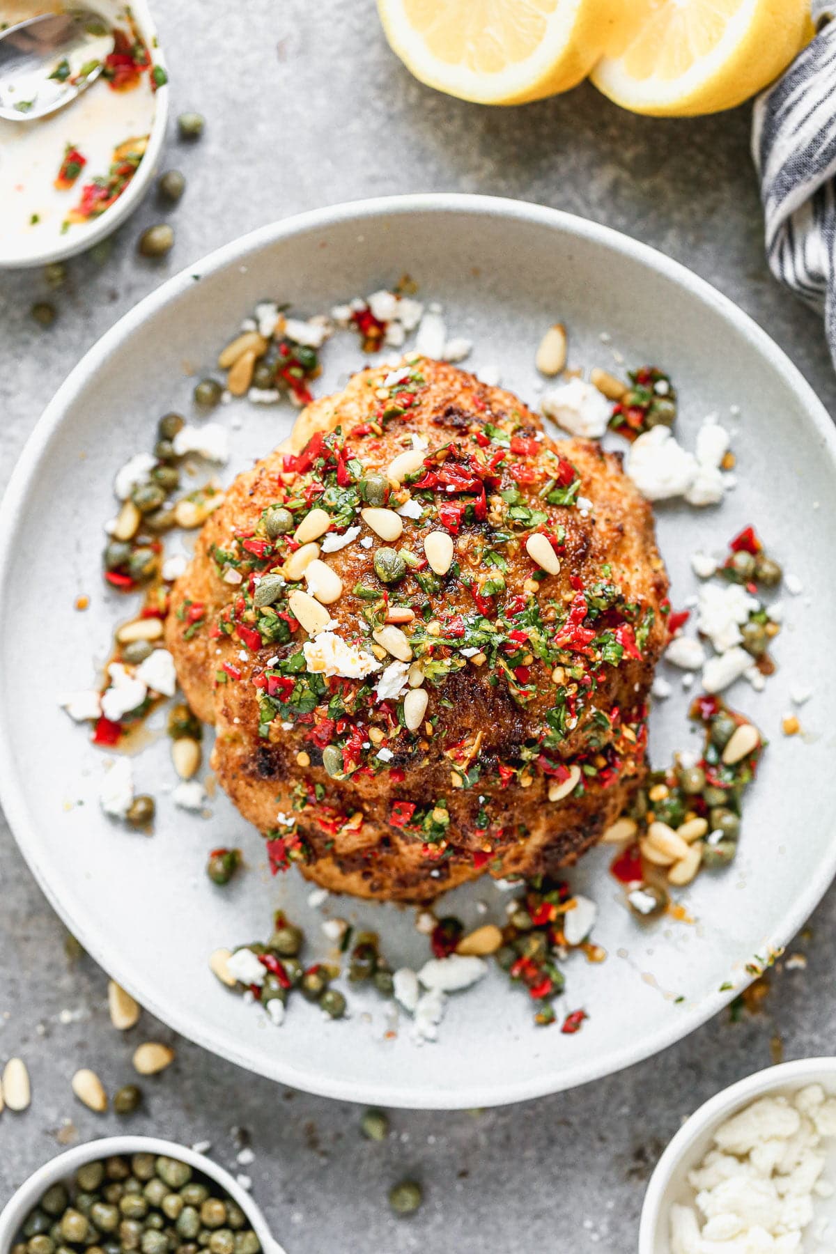 Visually beautiful and even tastier to eat, our Whole Roasted Cauliflower is THE vegetable recipe worthy of a permanent place in your dinner rotation. We steam a whole head of cauliflower, rub with with spices and then roast until it's tender on the inside and ultra crispy on top.  We cover it in an easy Calabrian Chili Chimichurri, sprinkle with toasted pine nuts, and finish it off with salty feta cheese. Eat a whole one for a meal or share with others as a side dish.