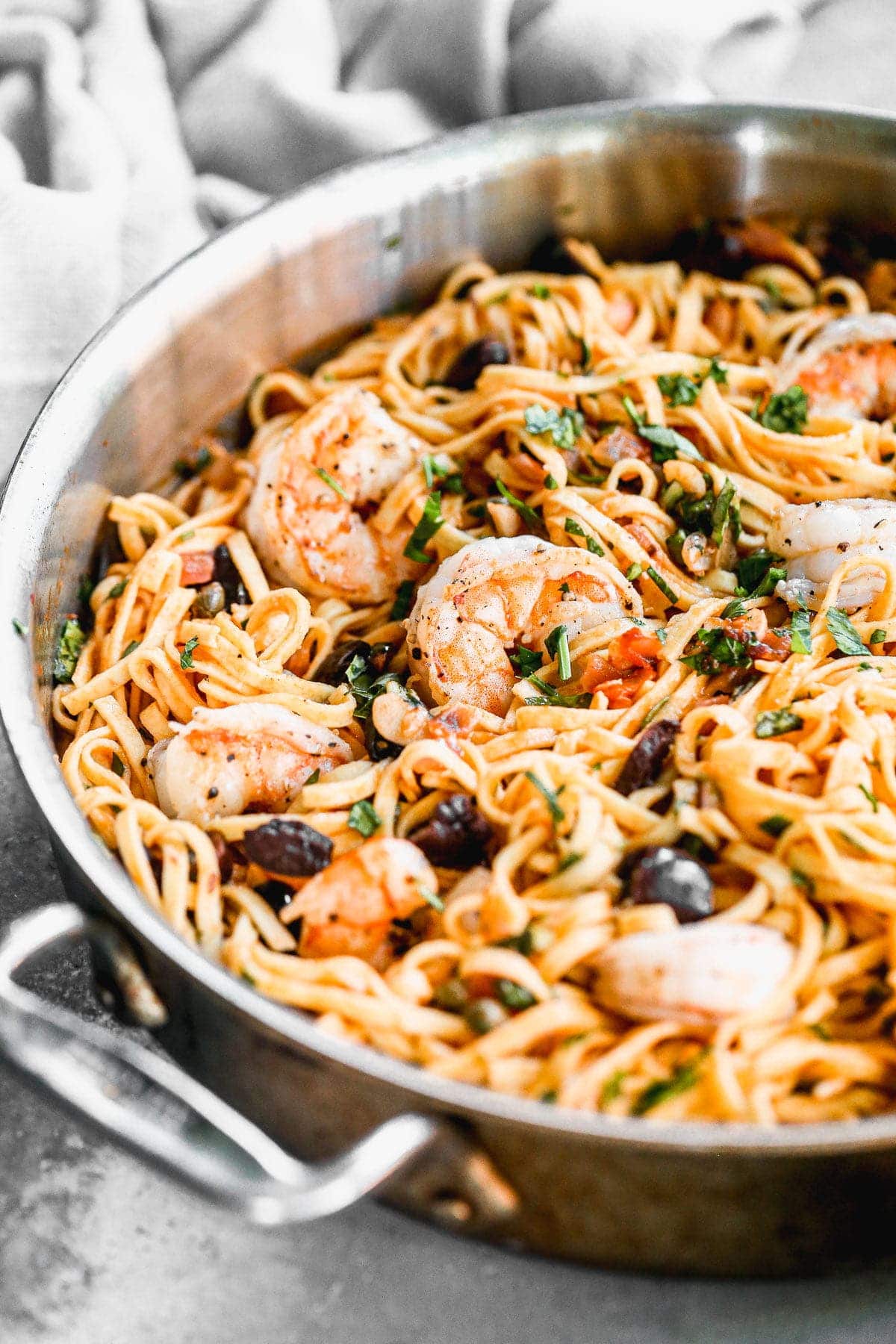 A classic pasta - shrimp puttanesca - showcases all the thing I love about the Mediterranean diet. Fresh linguine noodles are tossed with a impossibly simple tomato infused white wine sauce and studded with briny, salty capers and olives. With a heavy hand of garlic and a sprinkling of freshly grated parmesan cheese, this easy pasta dish manages to be utterly delicious and light and healthy at the same time. 