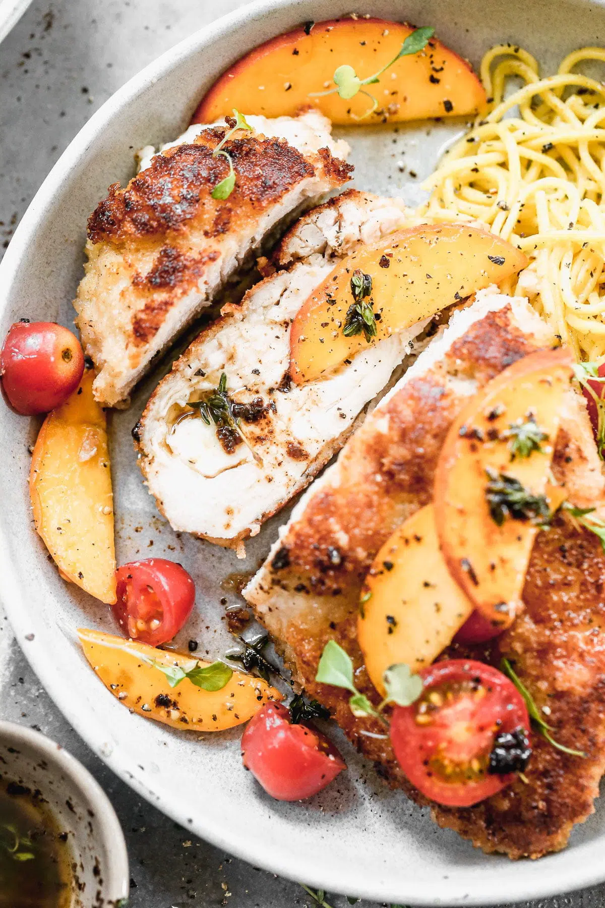 If summer were showcased on a plate it would surely be in the form of our Mozzarella-Stuffed Peach Chicken. This ultra crispy on the exterior, cheesy and tender on the interior winner of a chicken dish is adorned with the sweetest peaches and tomatoes and then drizzled with an intoxicating combination of brown butter, thyme, and lemon. You don't want to miss it!