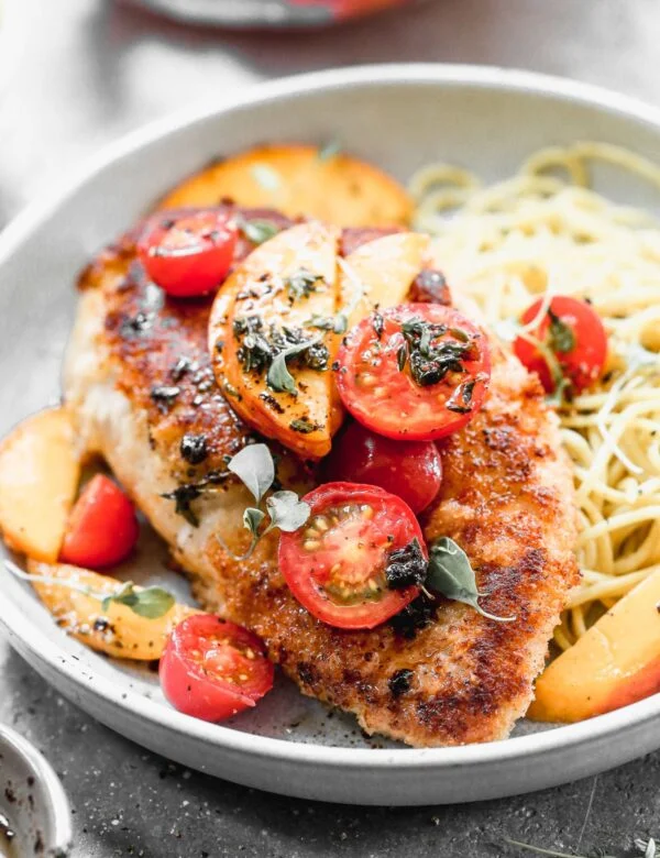 If summer were showcased on a plate it would surely be in the form of our Mozzarella-Stuffed Peach Chicken. This ultra crispy on the exterior, cheesy and tender on the interior winner of a chicken dish is adorned with the sweetest peaches and tomatoes and then drizzled with an intoxicating combination of brown butter, thyme, and lemon. You don't want to miss it!