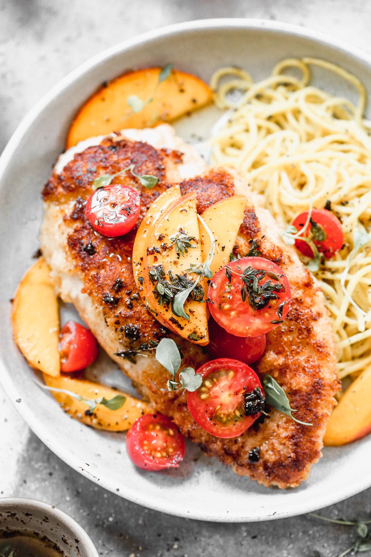 If summer were showcased on a plate it would surely be in the form of our Mozzarella-Stuffed Peach Chicken. This ultra crispy on the exterior, cheesy and tender on the interior winner of a chicken dish is adorned with the sweetest peaches and tomatoes and then drizzled with an intoxicating combination of brown butter, thyme, and lemon. You don't want to miss it!